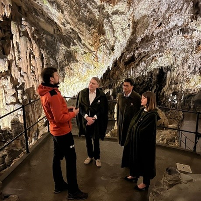 IOI President, Chris Field PSM, Human Rights Ombudsman of the Republic of Slovenia, Peter Svetina, and Chief of Staff to the IOI President, Rebecca Poole, being provided a guided tour of Postojna Cave