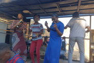 Ruth Lupanga (far left), civic education officer at the Office of the Ombudsman, dances with patrons at a public rally