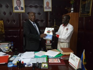 Advocacy and Communications Manager, Sammy Cheboi, presents a gift to Nakuru County Government County Secreretary, Mr Benjamin Njoroge, during a courtesy call in his office